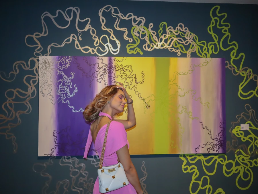 Visitors attending Rosana Auqué’s “Connection” art exhibition in Santa Marta, Colombia, surrounded by her circular abstract paintings in vibrant colors.